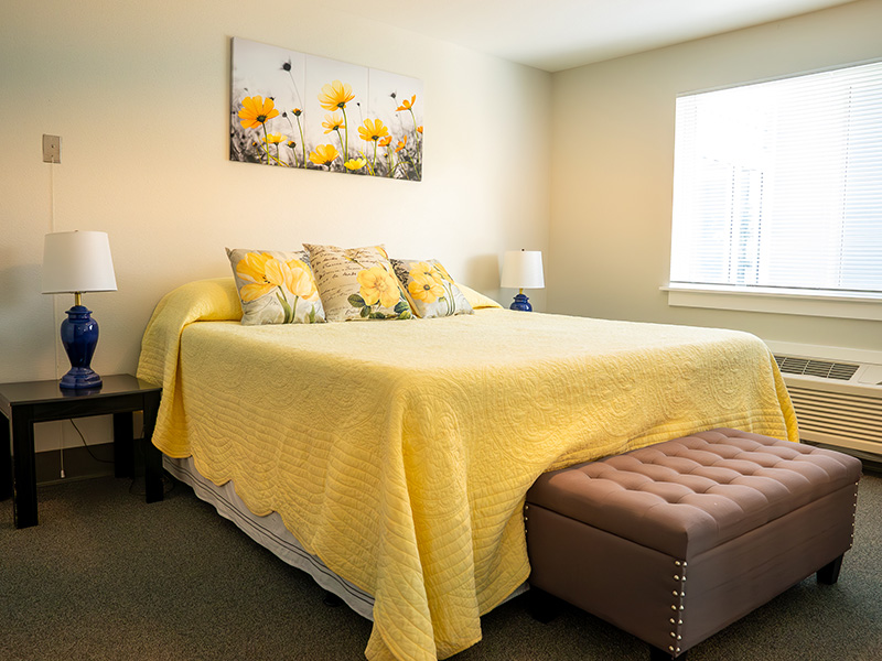 resident bedroom with bed covered in yellow bedspread