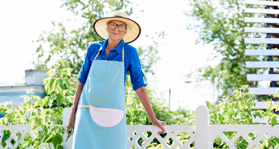 senior woman wearing a blue apron working in the garden